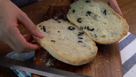 Fresh olive bread loaf cut into half Stock Footage 160156432
