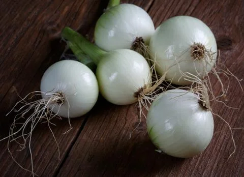 Fresh onions on brown rustic table Stock Photos