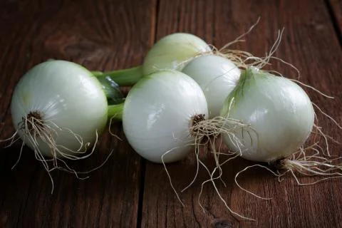 Fresh onions on rustic table Stock Photos