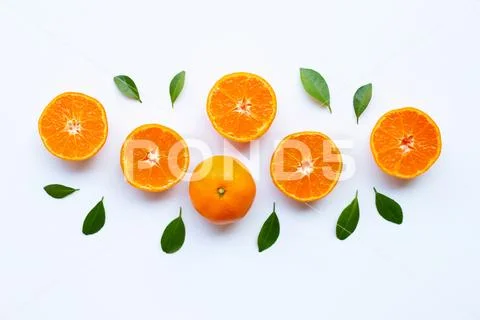 Fresh orange citrus fruit with green leaves on white. Stock Photos