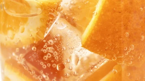 Fresh orange cocktail fruit pulp texture ice cubes fizzy bubbles in glass slow Stock Footage 182547849