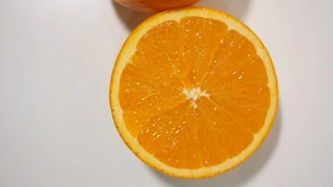 Fresh orange cut in half on white zoom and rotate close up Stock Footage 99259754