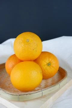 Fresh orange fruit on basket Stock Photos