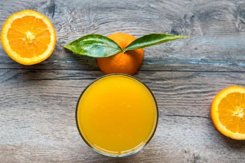 Fresh orange fruit with cut in half slice and green leaf glass of orange juic Stock Photos