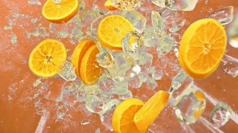 Fresh orange fruit, ice cube and drops juicy or alcohol beverage or energy drink Stock Footage 226505800