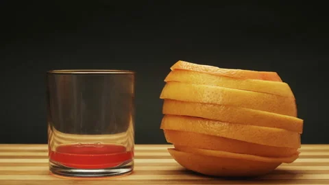 Fresh orange grapefruit is Squeezed Into a Glass. Stop Motion Animation Stock Footage 87833037