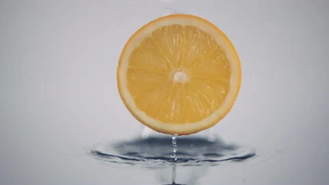 A fresh orange slice in circle shape falls down in slow motion Stock Footage 147233965
