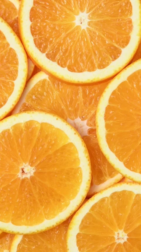 Fresh orange slices rotate in a vertical frame, revealing juicy citrus flesh and Stock Footage 346673182
