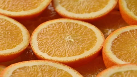 Fresh orange slices rotating around central citrus slice. 스톡 동영상 330469554