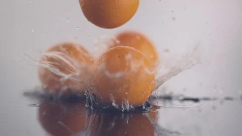 Fresh oranges fall from top onto a surface in slow motion Stock Footage 147232391