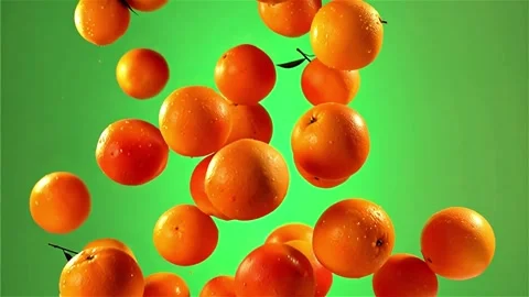 Fresh oranges falling with water drops on green background in slow motion Stock Footage 325126823