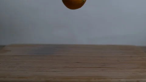 Fresh oranges fruit falling and bouncing on wooden surface Stock Footage 100005918