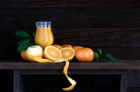 Fresh oranges with leaf and orange juice in glass on wooden table with plank  Stock Photos