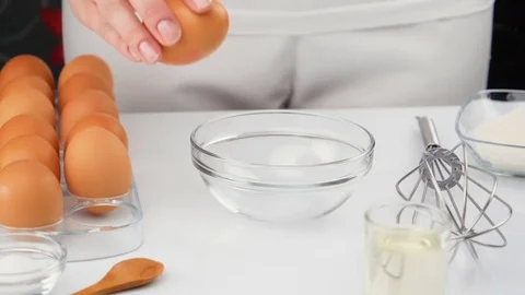 Fresh organic egg falling into glass bowl, slow motion Stock Footage 75910281