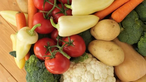 Fresh organic raw vegetables rotating on wooden background Stock Footage 337886180