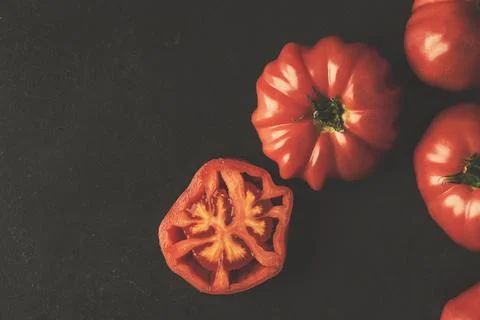 Fresh organic red tomatoes on rustic black background Stock Photos
