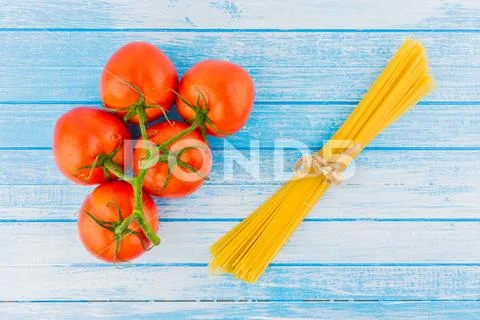 Fresh Organic Tomatoes With Waterdrops And Uncooked Italian Pasta With Strap Stock Photos