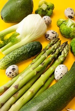Fresh organic vegetales for preparing healthy meal. Concept green on yellow.  Stock Photos