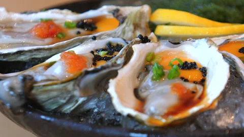 Fresh oysters on half shell with roe and scallions, served with lemon Stock-Footage 290779649