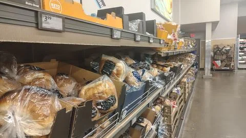 Fresh packaged bread on shelves in the bread section Stock Photos