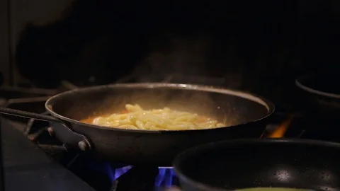 Fresh pasta being cooked in a pan in a restaurant kitchen. Vídeo Stock 96475597
