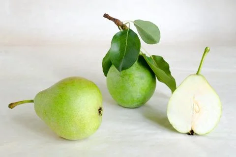 Fresh pears with leaves on a light background. Still life with pears. Stock Photos