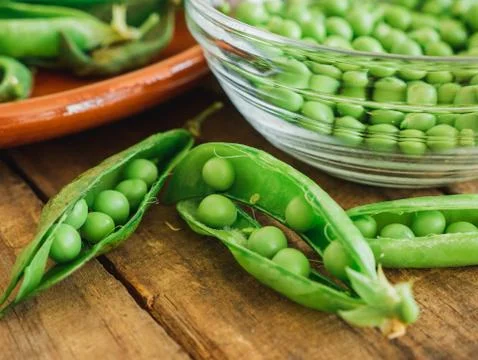 Fresh peas on the shells isolated on a table Foto stock