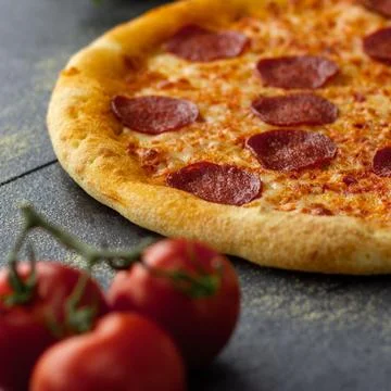 Fresh pepperoni pizza over a rustic background Stock Photos