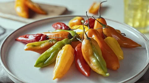 Fresh Peruvian ají amarillo and ají limo chili peppers on a ceramic plate Stock Footage 339078214