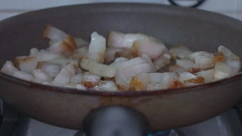 Fresh Pieces of Raw Bacon Frying in a Hot Non-Stick Kitchen Pan Stock Footage 339657992