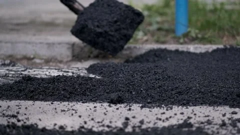 Fresh piles of hot steaming black asphalt dumped on the ground for pavement.. Stock Footage 339801982