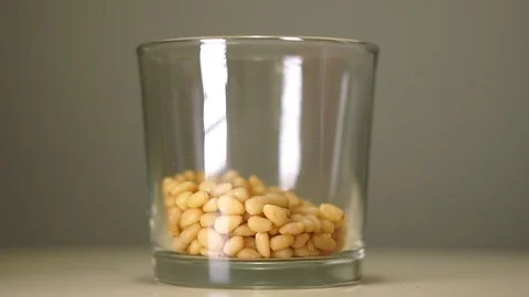 Fresh pine nuts in transparent glass with white reflection Stock-Footage 75241512