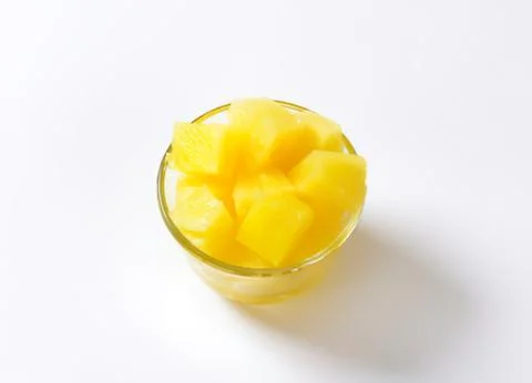 Fresh pineapple chunks in a clear glass bowl Stock Photos