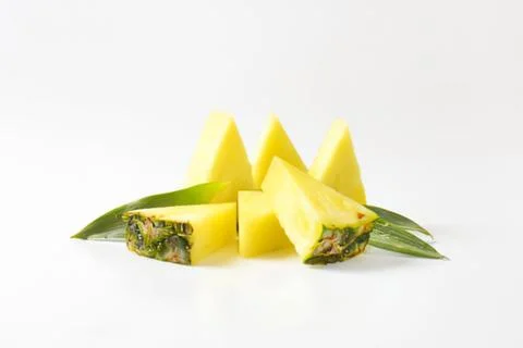 Fresh pineapple chunks with green leaf Stock Photos