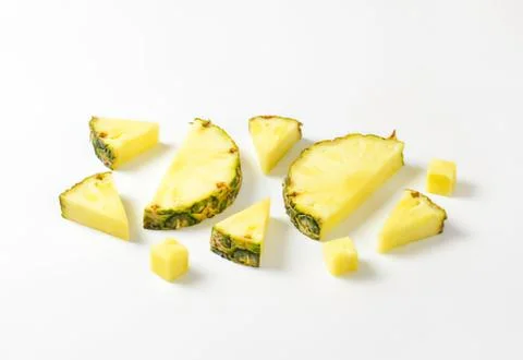 Fresh pineapple chunks on plain background Stock Photos