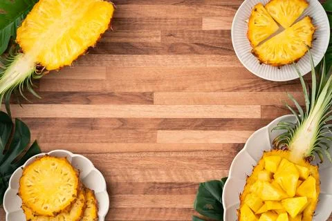 Fresh pineapple chunks served in a pineapple bowl on wooden table background. Foto stock