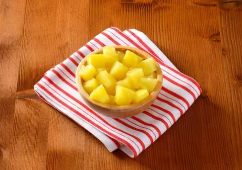 Fresh pineapple chunks on striped napkin Stock Photos