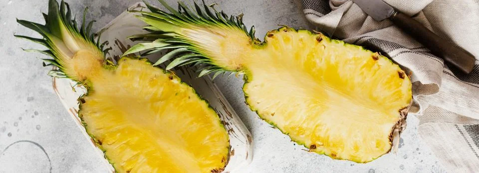 Fresh pineapple cut in two on gray concrete old background. Summer concept. C Stock Photos
