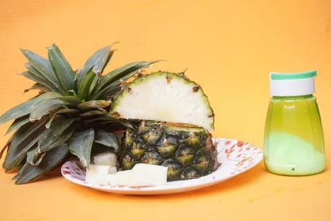 Fresh pineapple fruit with a refreshing smoothie, vibrant tropical drink 库存照片