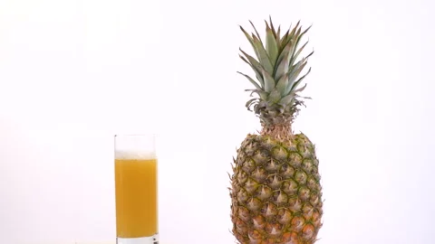 Fresh Pineapple Juice and Pineapple Rotating On A White Background Stock Footage 130297827