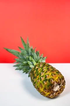 Fresh pineapple lying down on a white and red background. Stock Photos