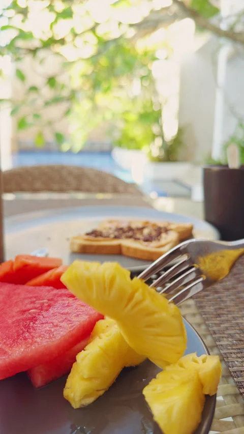 Fresh Pineapple Slice Lifted With Fork Above Tropical Breakfast Table Near Resor 库存影片 336812831