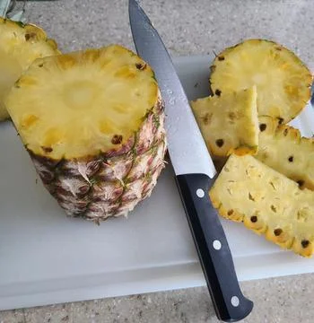 Fresh Pineapple Sliced on Cutting Board with Knife Stock Photos