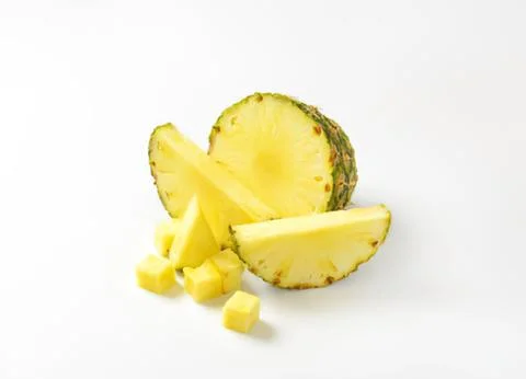 Fresh pineapple slices and chunks on plate Stock Photos