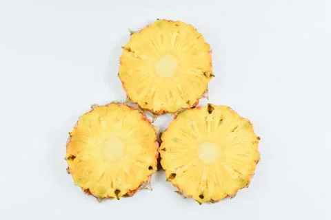 Fresh pineapple slices over white background. Tropical fruit. Stock Photos