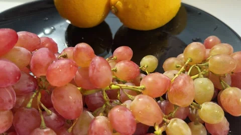 Fresh pink grapes Grapes fall on a cutting board with splashes of water. On a Stock Footage 316888890