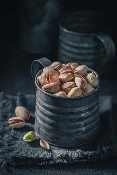 Fresh pistachios on dark table. Quick and good snack. Stock Photos
