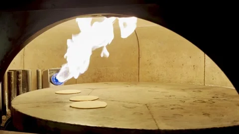 Fresh Pita Bread Inflating in Stone Oven Industrial with Burning Flame Stock Footage 333726050