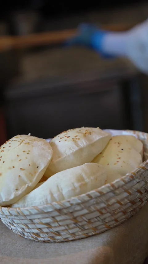 Fresh Pita Bread Moving into Wicker Basket Stock Footage 336593506