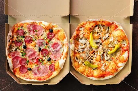 Fresh pizza in delivery box on dark concrete background. Top view, copy space Stock Photos